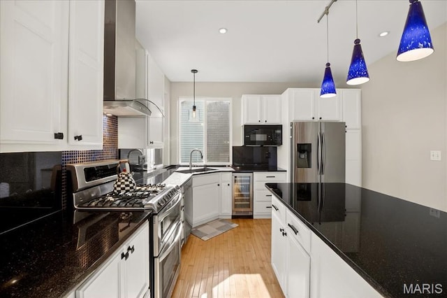 612 Thornridge Dr, Ofallon, MO 63368 - kitchen featuring appliances with stainless steel finishes, wine cooler, wall chimney range hood, light wood finished floors, and white cabinets