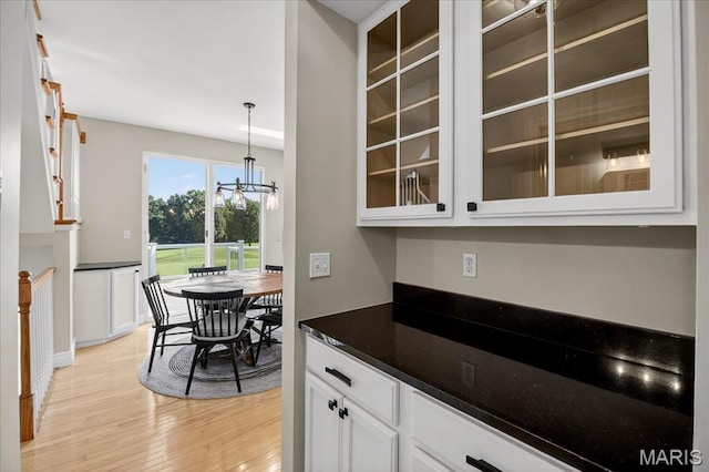 612 Thornridge Dr, Ofallon, MO 63368 - kitchen featuring light wood-style floors, glass insert cabinets, a chandelier, and white cabinets