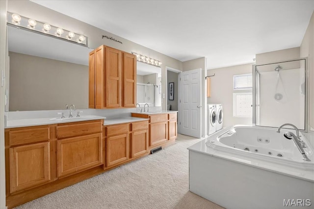 612 Thornridge Dr, Ofallon, MO 63368 - bathroom featuring independent washer and dryer, a stall shower, a tub with jets, and double vanity
