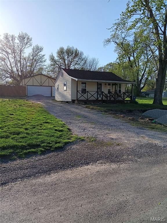 305 Stephenson Ave, South Roxana, IL 62087 - view of front of house featuring covered porch, gravel driveway, and a front yard