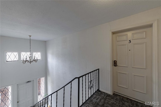 917 Claytonbrook Dr Unit 3, Ballwin, MO 63011 - foyer with a chandelier, a textured ceiling, and dark carpet
