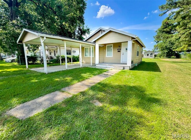 1309 E E Oak St, Dexter, MO 63841 - view of front of property with a front lawn, an attached carport, and a porch