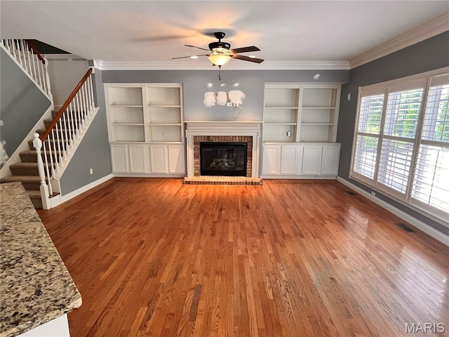 114 Cloverleaf Meadows Ct, Ofallon, MO 63366 - unfurnished living room with light wood-style flooring, ceiling fan, stairs, a fireplace, and ornamental molding