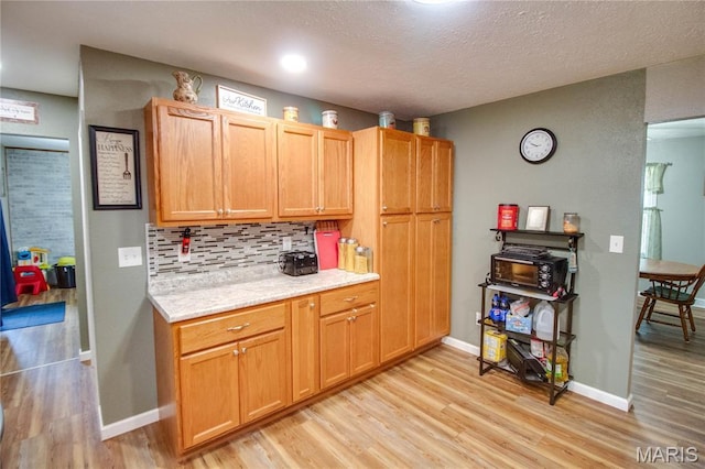 109 Hawbrook Pl, Jerseyville, IL 62052 - kitchen with light wood-type flooring, tasteful backsplash, and a textured ceiling