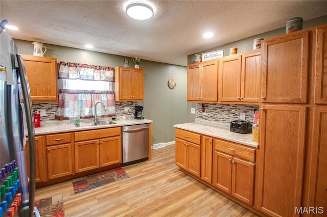 109 Hawbrook Pl, Jerseyville, IL 62052 - kitchen with appliances with stainless steel finishes, a textured ceiling, tasteful backsplash, light countertops, and light wood-style flooring