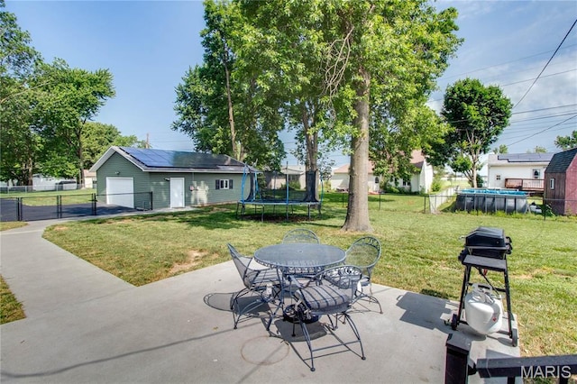 109 Hawbrook Pl, Jerseyville, IL 62052 - view of patio / terrace with a trampoline, a garage, an outbuilding, grilling area, and outdoor dining area