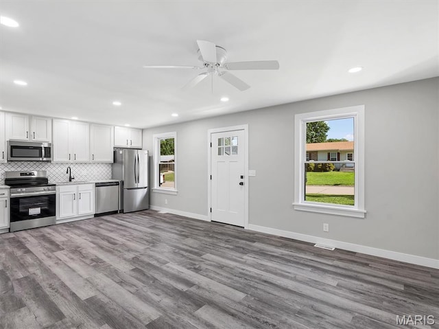 1505 Cypress Dr, Pacific, MO 63069 - kitchen with appliances with stainless steel finishes, healthy amount of natural light, wood finished floors, white cabinetry, and recessed lighting