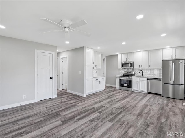 1505 Cypress Dr, Pacific, MO 63069 - kitchen with stainless steel appliances, a ceiling fan, backsplash, wood finished floors, and recessed lighting