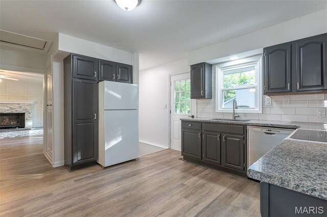 525 Oak Hill Dr, Lake St Louis, MO 63367 - kitchen with freestanding refrigerator, stainless steel dishwasher, light wood finished floors, backsplash, and stone counters