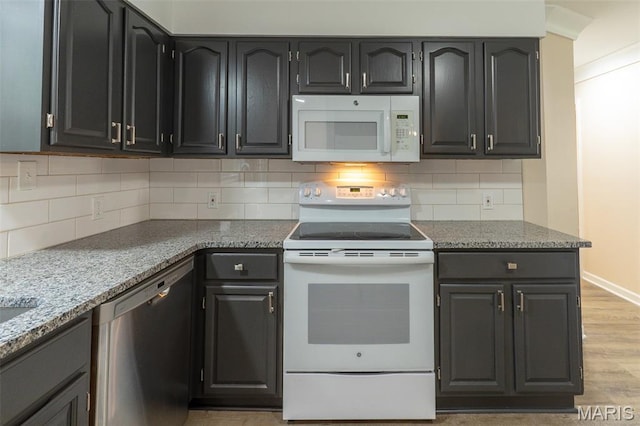 525 Oak Hill Dr, Lake St Louis, MO 63367 - kitchen with white appliances, light wood finished floors, backsplash, and light stone counters