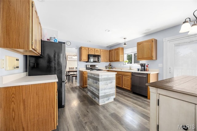 105 Royallmanor Ln, Ofallon, MO 63368 - kitchen with appliances with stainless steel finishes, dark wood-style flooring, a kitchen island, light countertops, and decorative light fixtures