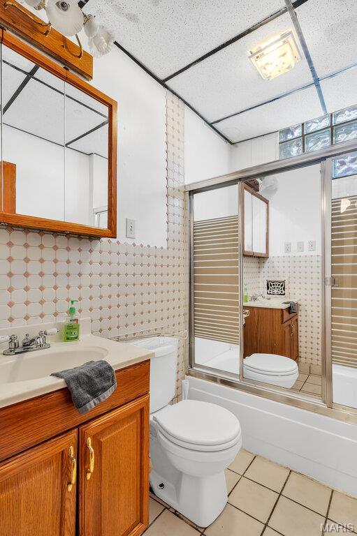 5447 Claxton Ave, Saint Louis, MO 63120 - bathroom with tile patterned floors, vanity, enclosed tub / shower combo, and wallpapered walls