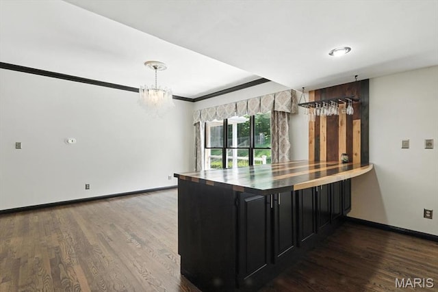 512 Overlook Terrace Ct, Eureka, MO 63025 - kitchen with dark cabinetry, wood finished floors, a chandelier, hanging light fixtures, and crown molding