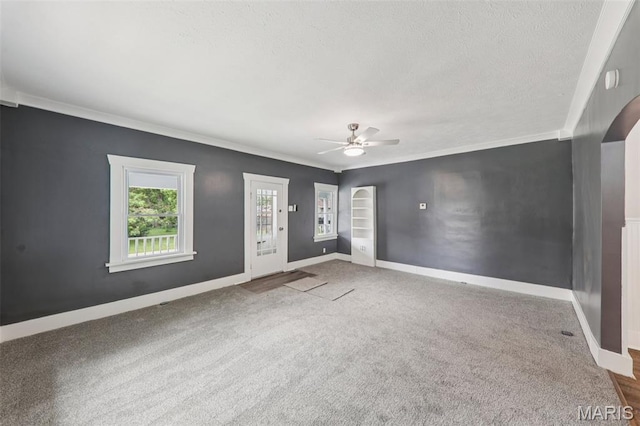 413 E Beach St, Litchfield, IL 62056 - unfurnished living room with ceiling fan, carpet, a textured ceiling, crown molding, and arched walkways