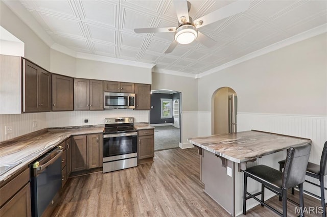 413 E Beach St, Litchfield, IL 62056 - kitchen featuring stainless steel appliances, arched walkways, a ceiling fan, dark wood-style flooring, and an ornate ceiling
