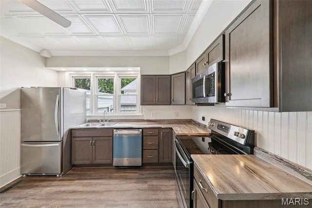 413 E Beach St, Litchfield, IL 62056 - kitchen with stainless steel appliances, wood finished floors, an ornate ceiling, dark brown cabinets, and light countertops