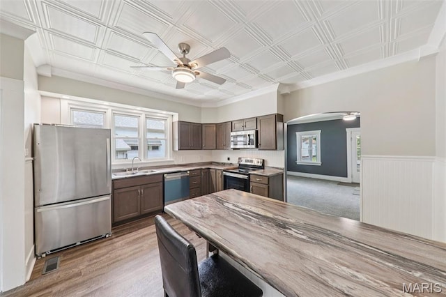 413 E Beach St, Litchfield, IL 62056 - kitchen with stainless steel appliances, ceiling fan, an ornate ceiling, arched walkways, and dark brown cabinetry