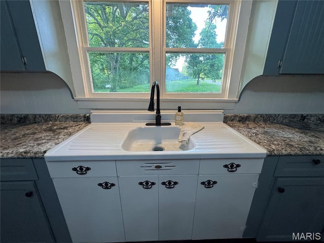 719 N 10th St, Poplar Bluff, MO 63901 - kitchen featuring backsplash, plenty of natural light, and blue cabinetry
