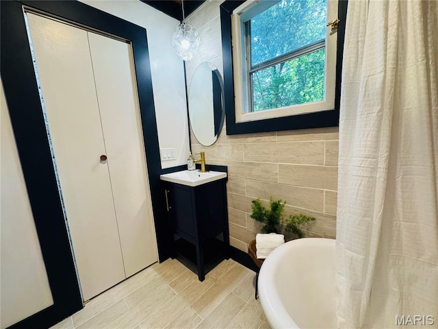 719 N 10th St, Poplar Bluff, MO 63901 - full bath with a freestanding bath, vanity, and wood finished floors