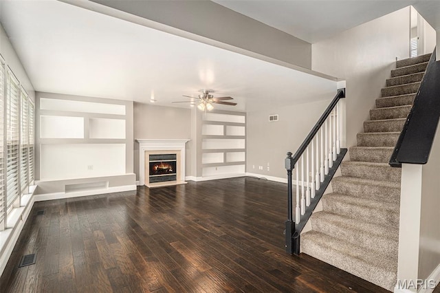 1016 Scenic Oaks Ct, Imperial, MO 63052 - unfurnished living room with hardwood / wood-style flooring, ceiling fan, stairway, and a lit fireplace
