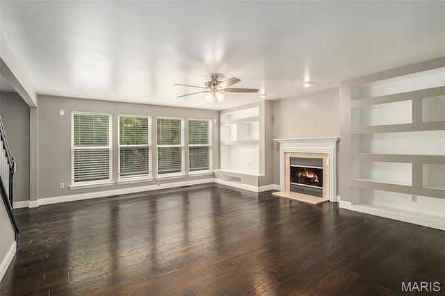 1016 Scenic Oaks Ct, Imperial, MO 63052 - unfurnished living room featuring a ceiling fan, a lit fireplace, dark wood-style flooring, and built in shelves