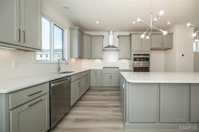 8971 Eager Rd, Richmond Heights, MO 63144 - kitchen with appliances with stainless steel finishes, gray cabinetry, wall chimney exhaust hood, light countertops, and tasteful backsplash