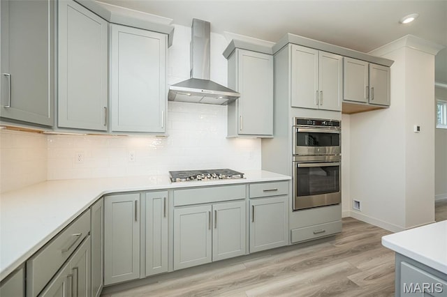 8971 Eager Rd, Richmond Heights, MO 63144 - kitchen with wall chimney exhaust hood, stainless steel appliances, gray cabinets, light wood-style flooring, and recessed lighting