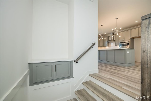 8971 Eager Rd, Richmond Heights, MO 63144 - staircase featuring a chandelier and wood finished floors