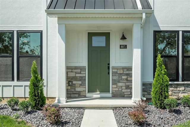 8971 Eager Rd, Richmond Heights, MO 63144 - doorway to property with a standing seam roof, stone siding, and covered porch