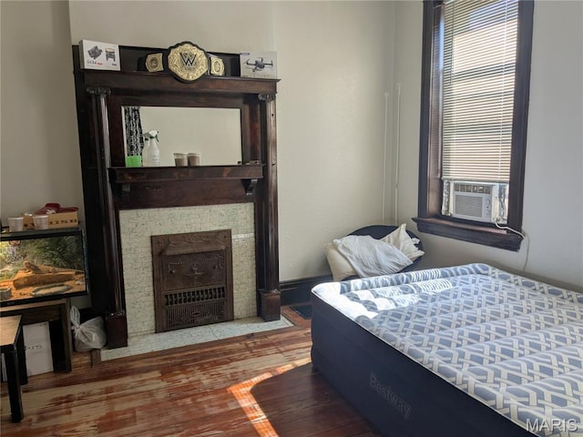 3744 Michigan Ave, Saint Louis, MO 63118 - bedroom featuring cooling unit, wood finished floors, and a fireplace with flush hearth