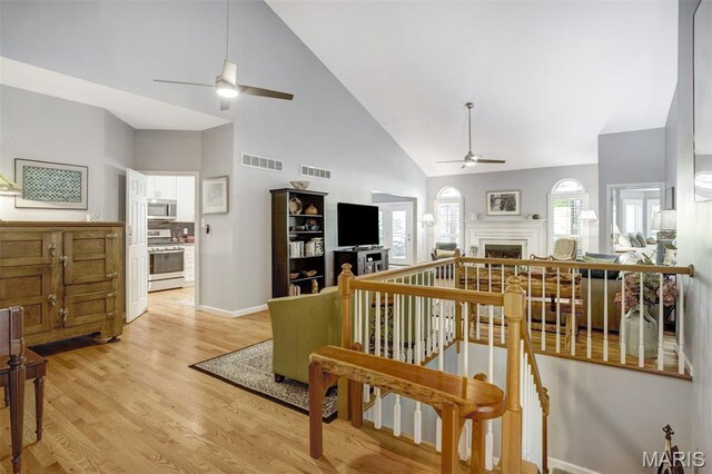1168 Oak Knoll Manor Ct, Saint Louis, MO 63119 - living area with ceiling fan, high vaulted ceiling, a fireplace, and light wood-type flooring
