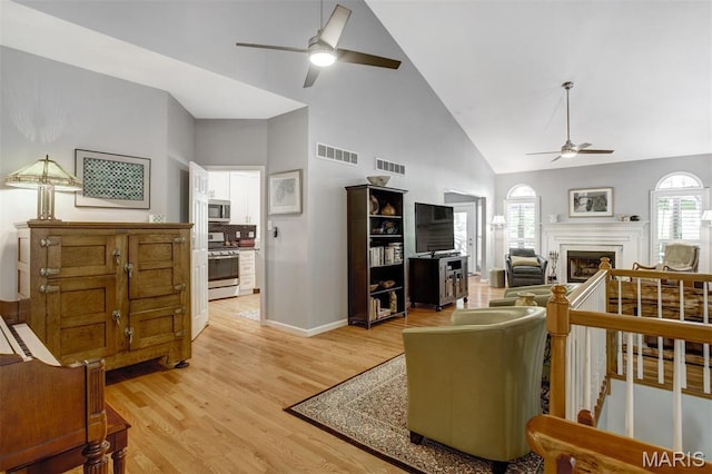 1168 Oak Knoll Manor Ct, Saint Louis, MO 63119 - living room with ceiling fan, high vaulted ceiling, light wood-type flooring, and a fireplace