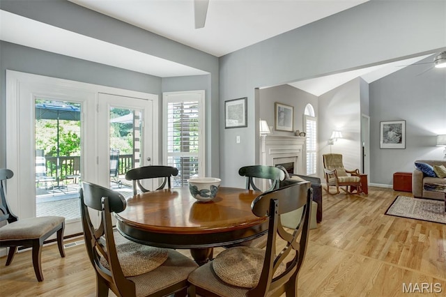 1168 Oak Knoll Manor Ct, Saint Louis, MO 63119 - dining room featuring a ceiling fan, a fireplace, light wood-type flooring, and vaulted ceiling