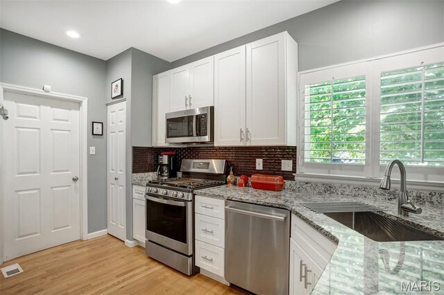1168 Oak Knoll Manor Ct, Saint Louis, MO 63119 - kitchen featuring stainless steel appliances, light stone counters, backsplash, white cabinets, and recessed lighting