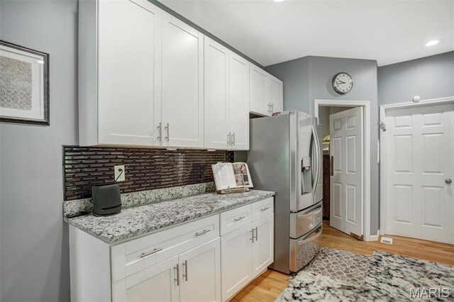 1168 Oak Knoll Manor Ct, Saint Louis, MO 63119 - kitchen featuring stainless steel fridge, white cabinetry, tasteful backsplash, light wood-type flooring, and light stone counters