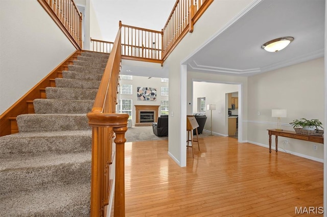 1211 Conrad Ln, Ofallon, IL 62269 - stairs featuring hardwood / wood-style floors, a glass covered fireplace, and a high ceiling