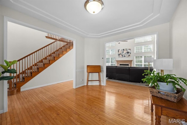 1211 Conrad Ln, Ofallon, IL 62269 - living room featuring stairway, a raised ceiling, wood-type flooring, and a fireplace