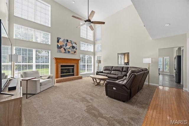 1211 Conrad Ln, Ofallon, IL 62269 - carpeted living area with a ceiling fan, high vaulted ceiling, a brick fireplace, and hardwood / wood-style floors