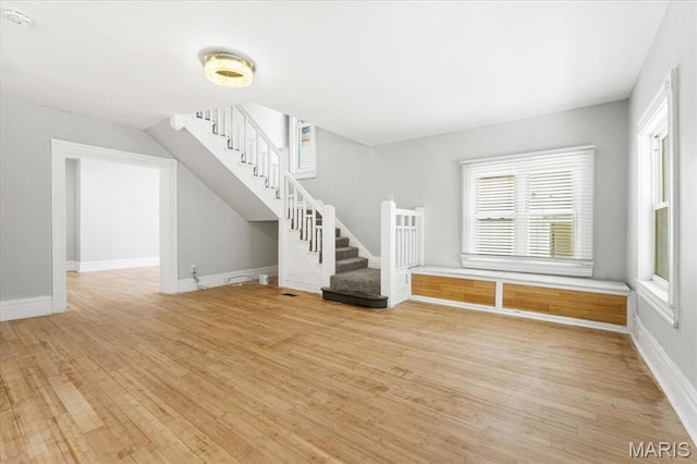 5829 Bartmer Ave, Saint Louis, MO 63112 - unfurnished living room featuring stairway and light wood-style floors