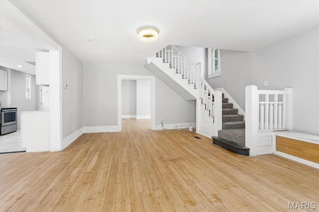 5829 Bartmer Ave, Saint Louis, MO 63112 - unfurnished living room featuring stairs and light wood-style floors