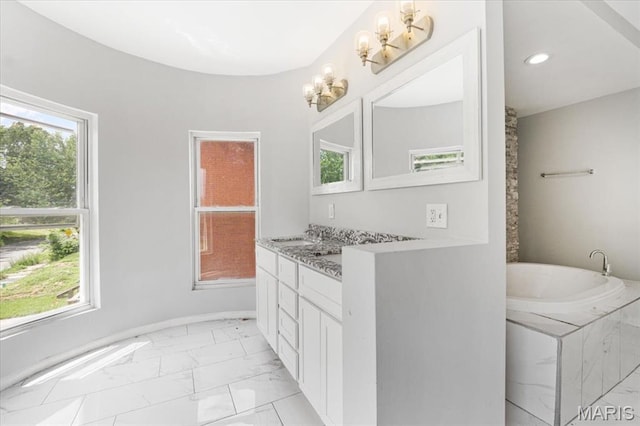 5829 Bartmer Ave, Saint Louis, MO 63112 - bathroom with marble look tiles, vanity, plenty of natural light, a garden tub, and recessed lighting