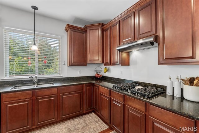 1412 Heritage Valley Dr, High Ridge, MO 63049 - kitchen with under cabinet range hood, black gas cooktop, decorative light fixtures, and dark stone countertops