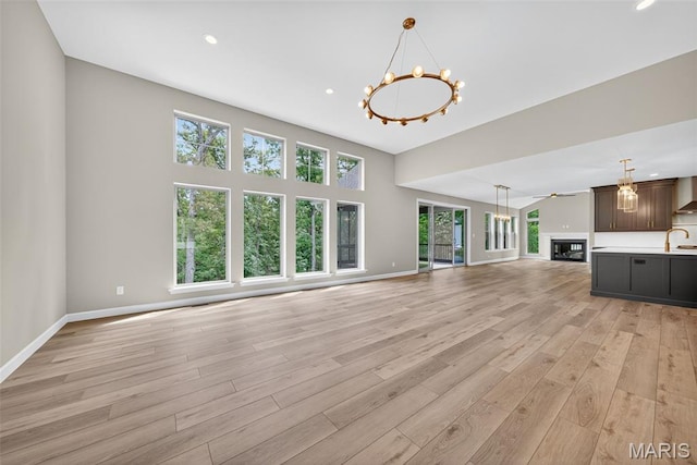 212 Terradel Trl, Foristell, MO 63348 - unfurnished living room featuring a chandelier, light wood-type flooring, a glass covered fireplace, and recessed lighting