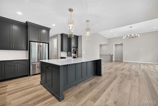 212 Terradel Trl, Foristell, MO 63348 - kitchen with stainless steel refrigerator, light countertops, light wood-style floors, decorative light fixtures, and recessed lighting