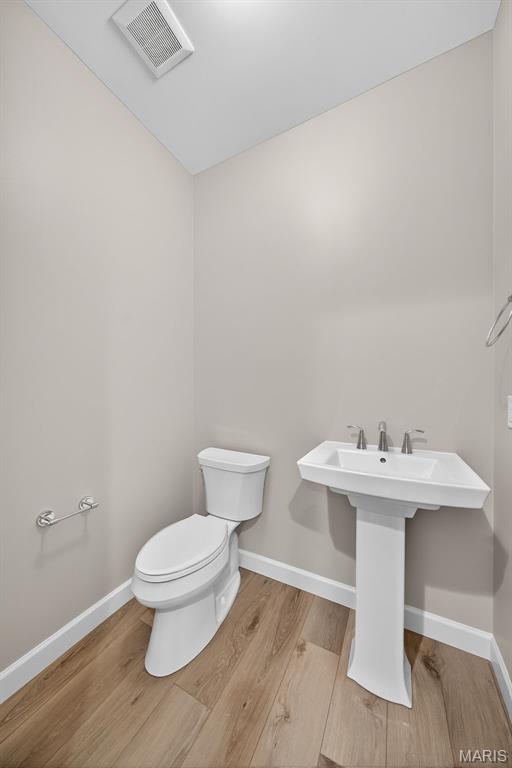 212 Terradel Trl, Foristell, MO 63348 - half bathroom featuring toilet and wood finished floors