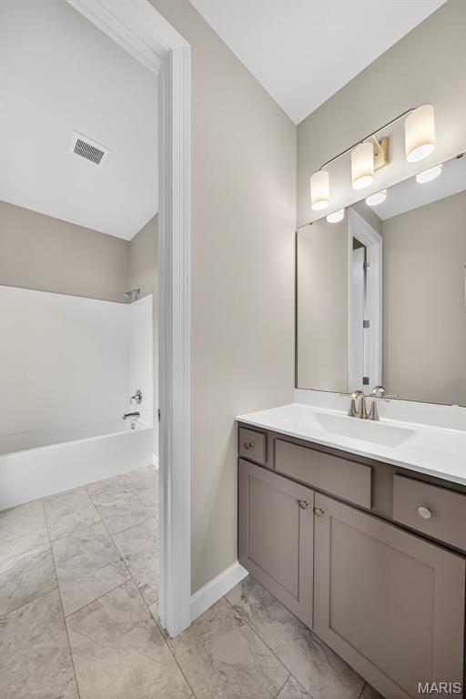 212 Terradel Trl, Foristell, MO 63348 - full bathroom featuring marble look tiles, vanity, and shower / tub combination