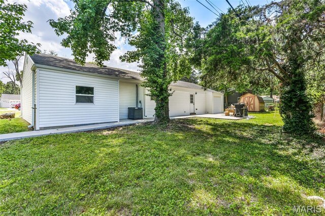 715 Westchester Ct, Kirkwood, MO 63122 - rear view of house featuring a storage unit, a patio area, a yard, and a garage