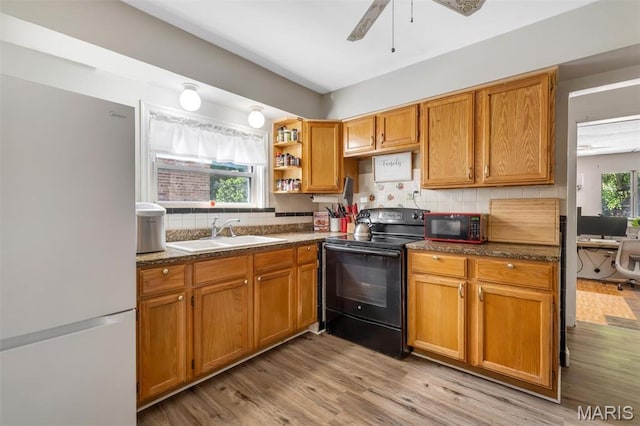 1164 Ursula Ave, University City, MO 63130 - kitchen with black appliances, tasteful backsplash, dark countertops, and light wood-type flooring