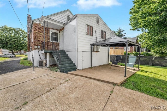 1164 Ursula Ave, University City, MO 63130 - rear view of house featuring a gazebo, a patio area, brick siding, a wall mounted AC, and a chimney