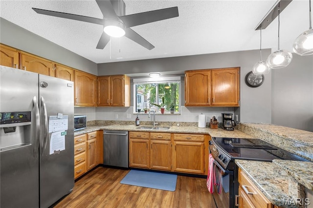 391 Carriage Trail Ct, Ofallon, MO 63368 - kitchen featuring appliances with stainless steel finishes, dark wood-type flooring, brown cabinetry, a ceiling fan, and a textured ceiling